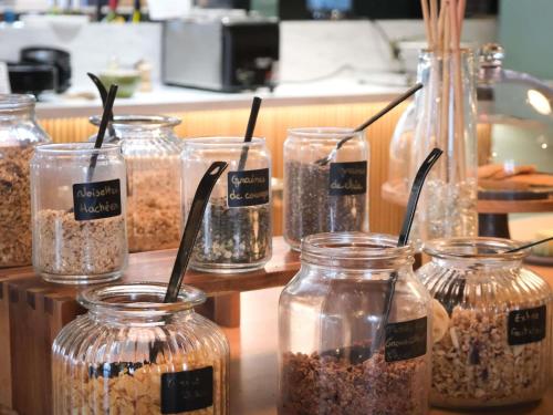 een groep potten gevuld met haver op een aanrecht bij Mercure Saint Omer Centre Gare in Saint-Omer