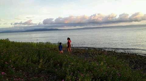 two people standing on a hill looking at the water at Hostal La Cascada San Ramón in Mérida