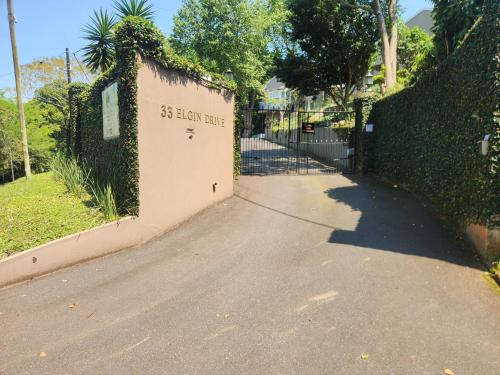 a gate to a house with a driveway at Maple Tree Manor in Durban