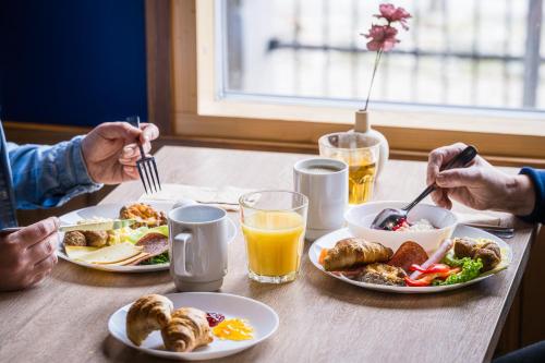 a group of people sitting at a table eating breakfast at Hotel Arctic Zone in Ruka