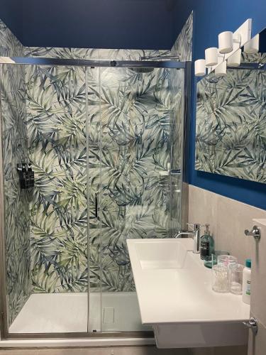 a bathroom with a shower with a sink and a mirror at B&B IL QUADRIFOGLIO in Iesi