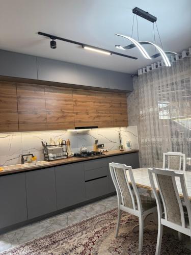 een keuken met een tafel en stoelen in een keuken bij TaTa Guest House in Bisjkek