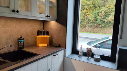 a kitchen with a sink and a window at Villa AIMÉ SALMCHÂTEAU in Vielsalm