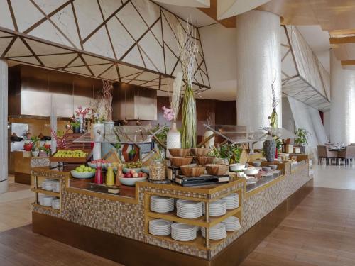 a kitchen with a buffet of food on display at Swissôtel Al Ghurair Dubai in Dubai