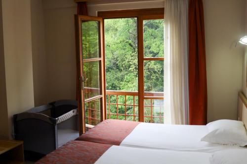 een slaapkamer met een bed en een groot raam bij Sağlık Bakanlığı Yalova Termal Kaplıcaları in Termal