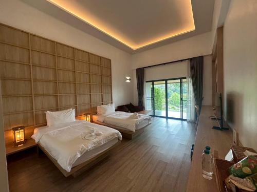 a hotel room with two beds and a couch at PASSA ผัสสะ Tea Plantation @Mae On in Ban Huai Kaeo