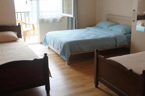 a bedroom with two beds and a window at Guest House Mari in Ureki