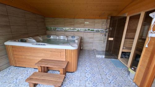 a sauna with a tub and a table and a stool at Zamárdi Trafóház in Zamárdi