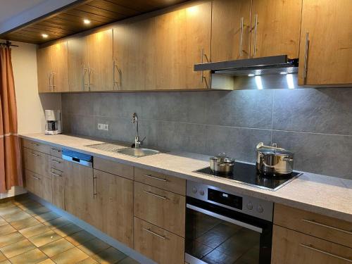 a kitchen with wooden cabinets and a stove top oven at Haus Renard in Rodund