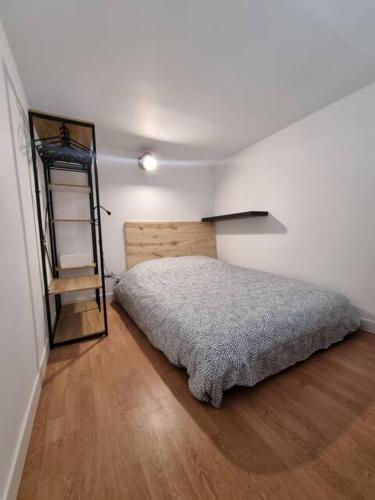 Charmant Studio en Duplex في مارسيليا: غرفة نوم مع سرير وأرضية خشبية