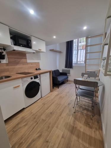 Charmant Studio en Duplex في مارسيليا: مطبخ وغرفة معيشة مع طاولة وكراسي