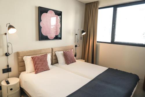 a bedroom with two beds and a window at Bessa Apartments - Growhome in Porto