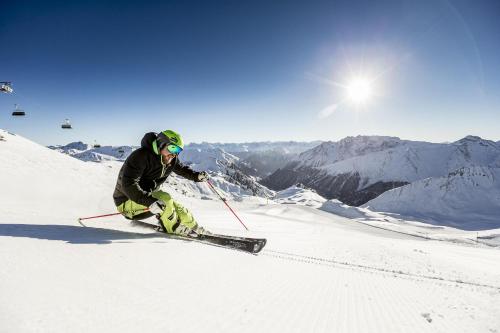 a person is skiing down a snow covered mountain at Hotel Nevada in Samnaun