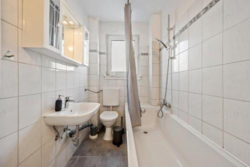 a white bathroom with a sink and a toilet at BIR02 Wohnung mit Garten in Rüsselsheim! in Rüsselsheim
