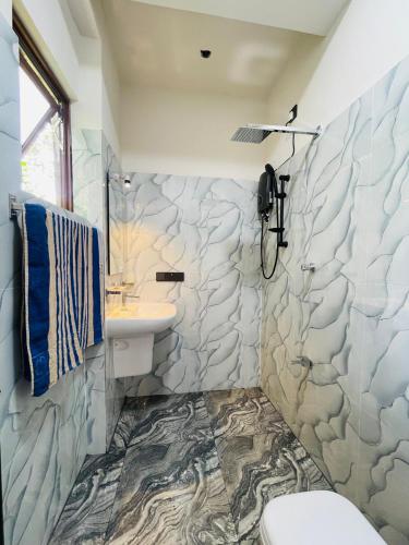 a bathroom with a sink and a stone wall at Bosilu Villa in Weligama