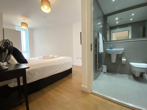 a bathroom with a bed and a sink and a toilet at Bracknell RWH Spectacular Two Bedroom Apartment in Bracknell