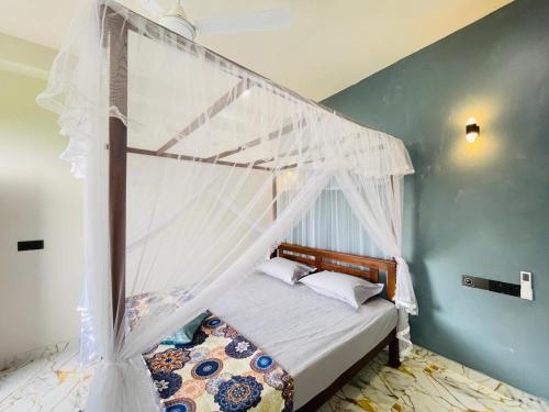 a bedroom with a bed with a white canopy at Bosilu Villa in Weligama