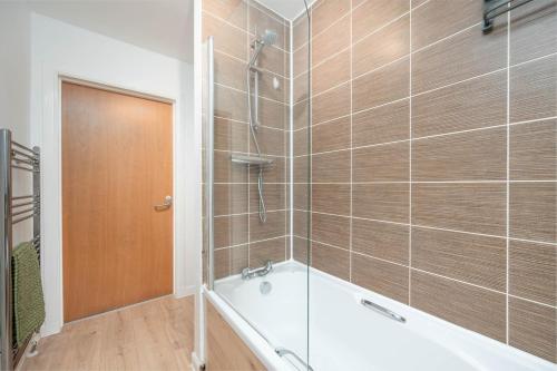 un baño con bañera y ducha en Aberdeen 2BR Flat Near Airport & City Centre, en Aberdeen
