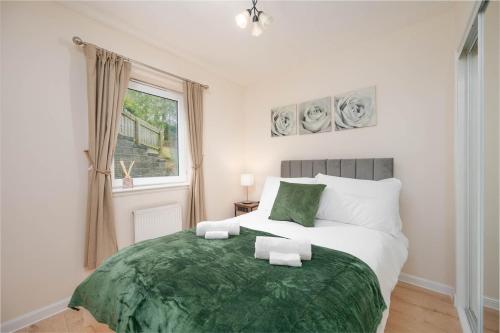 Un dormitorio con una cama grande con una manta verde. en Aberdeen 2BR Flat Near Airport & City Centre, en Aberdeen