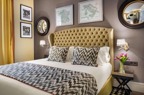 a bedroom with a large bed with a large headboard at NH Collection Colón Valencia in Valencia