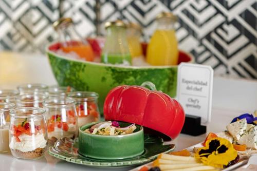 a table topped with bowls of food and desserts at NH Collection Colón Valencia in Valencia