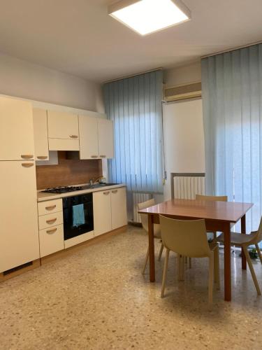a kitchen with a wooden table and a dining room at B&B IL QUADRIFOGLIO in Iesi