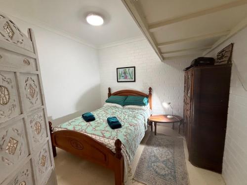 a small bedroom with a bed and a table at Cod Place in Beautiful South West Rocks in South West Rocks
