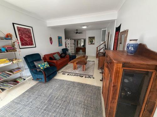 a living room with a red couch and a chair at Cod Place in Beautiful South West Rocks in South West Rocks