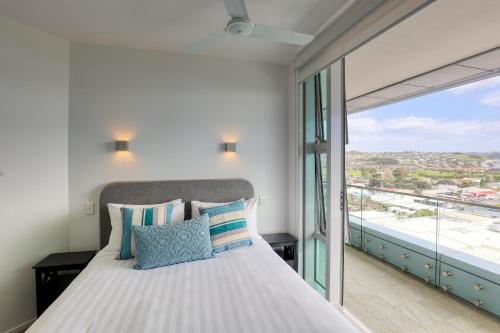 オレワにあるMarsden Suites Nautilus Orewaのベッドと大きな窓のある寝室