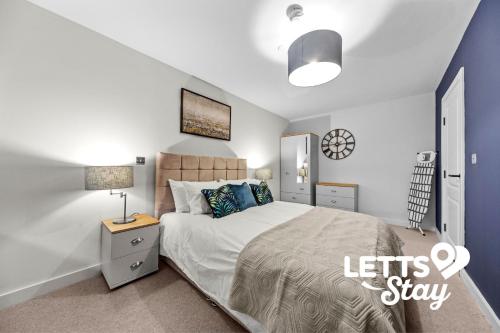 een slaapkamer met een kingsize bed met een nachtkastje bij The Old Schoolhouse in Leeds