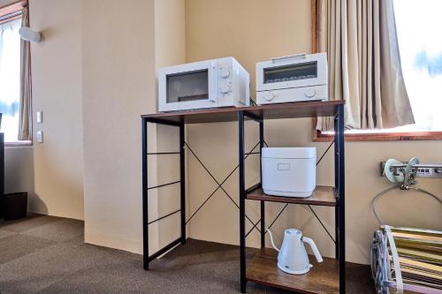 a room with a table with two microwaves and a microwave at ホステル サクヤ in Fujiyoshida
