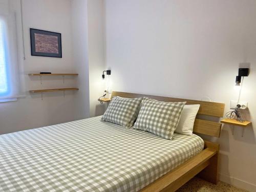 a bedroom with a bed with checkered sheets and pillows at Casa Soñiga - Congost de Montrebei in Tolva