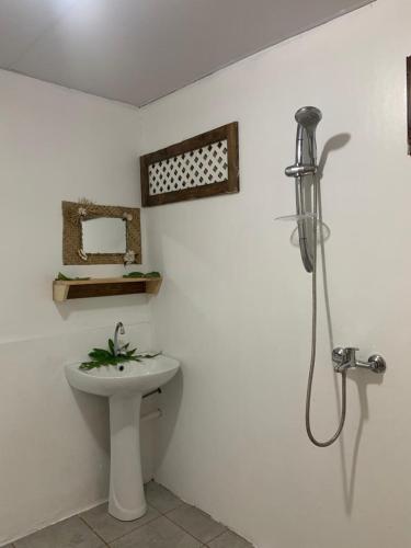 a bathroom with a toilet and a sink and a shower at Kura Ora Guest House in Rangiroa