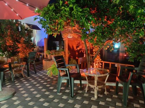 a restaurant with chairs and tables and trees at Guest House Adilaj in Berat