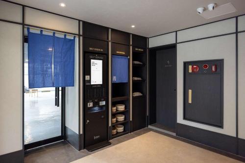 a walk in closet with black cabinets and a window at Mitasuya Ryokan Hotel Daejeon Yuseong in Daejeon