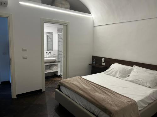 una camera da letto con un letto e un bagno con un lavandino di L' Antico Borgo Ibla a Ragusa