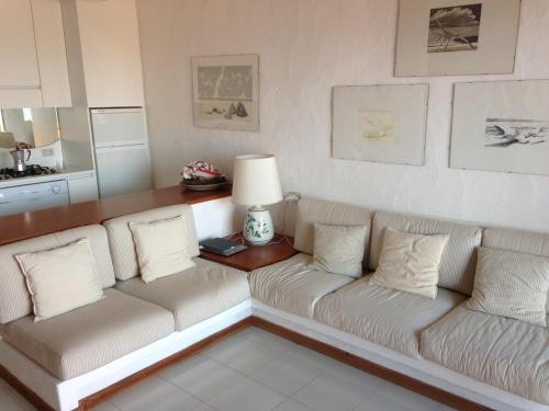 a living room with two white couches and a table at Villaggio Est a Capo Coda Cavallo San Teodoro in San Teodoro