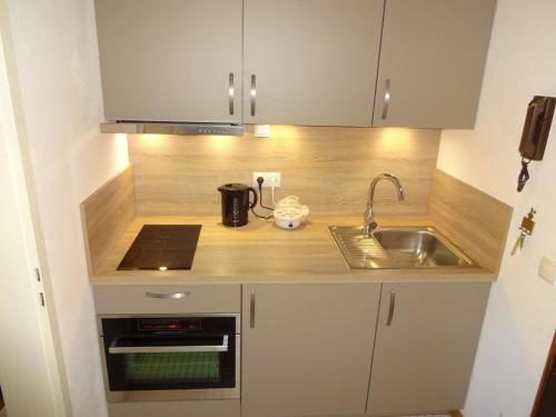 une petite cuisine avec un évier et un micro-ondes dans l'établissement Ferienwohnung F239 für 2-4 Personen an der Ostsee, à Schönberg in Holstein