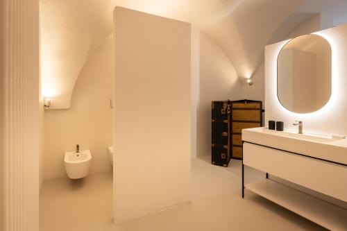 een witte badkamer met een wastafel en een spiegel bij Palazzo Villani Lubelli in Cannole