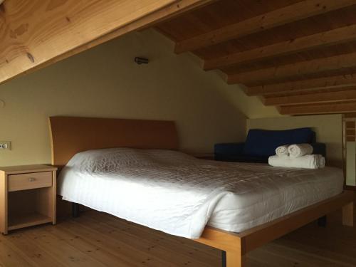 a bedroom with a large bed with white sheets at Hani Inn in Lygourio