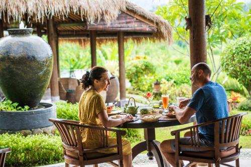 a man and a woman sitting at a table at Surya Shanti Villa Sidemen in Sidemen