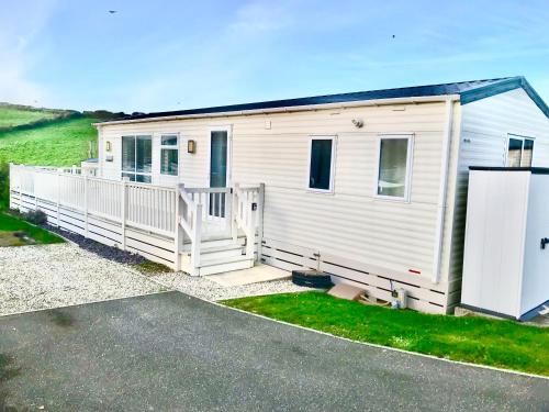 a white tiny house with a large porch at NV45 Beautiful durdle door holiday park in West Lulworth