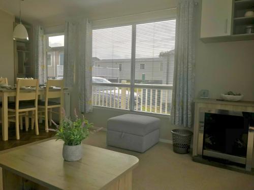 a living room with a table and a fireplace at NV45 Beautiful durdle door holiday park in West Lulworth