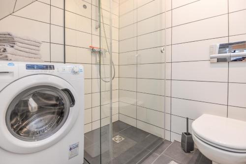 une salle de bains avec lave-linge et toilettes dans l'établissement Žalia kopa near the beach apartments, à Palanga