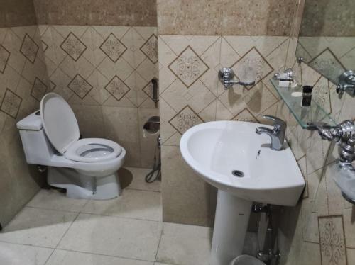 a bathroom with a toilet and a sink at Moon Living Apartment Peshawar in Peshawar