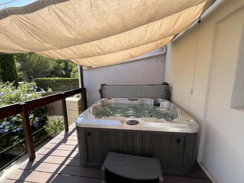 a jacuzzi tub on a balcony with a canopy at Villa de l'oustaoun in Sanary-sur-Mer