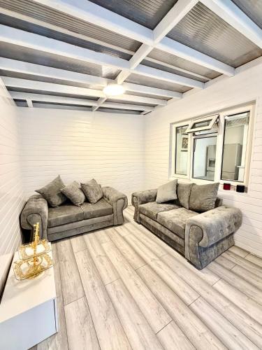 a living room with two couches and a table at 4 Bedroom House CheapUKholiday in Dagenham