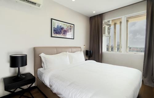 a bedroom with a white bed and a window at CASA by Meridian in Phnom Penh