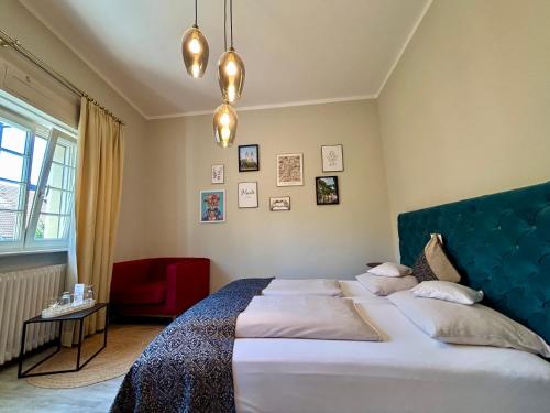 une chambre avec un grand lit et une chaise rouge dans l'établissement Bio Boutique Hotel Barbara, à Fribourg-en-Brisgau