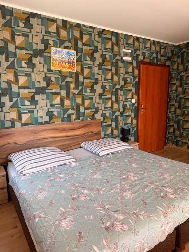 a bedroom with a bed and a wall with a pattern at Dom wczasowy Max in Darłowo